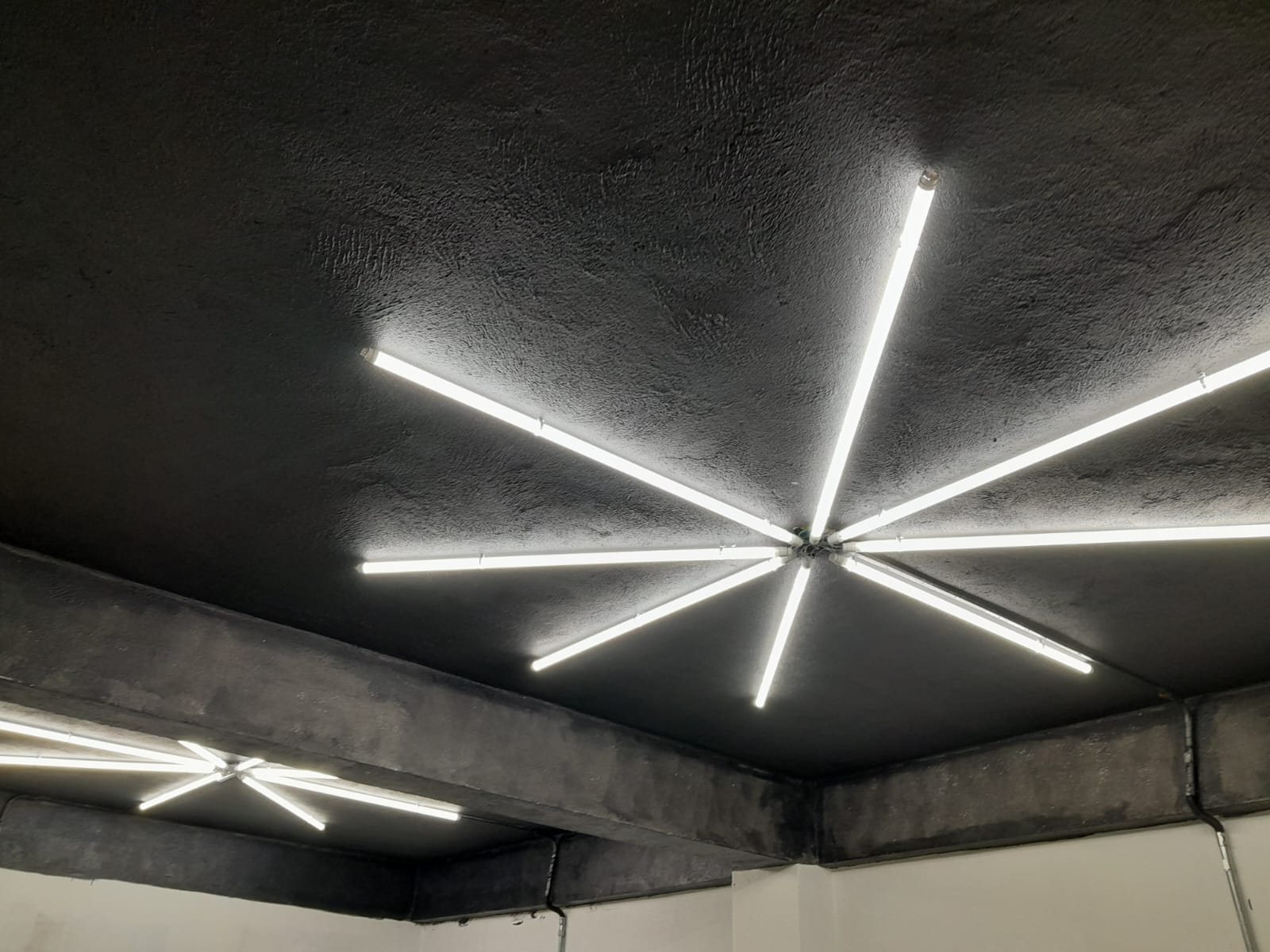 Luminária de LED em formato de estrela instalada em teto de concreto