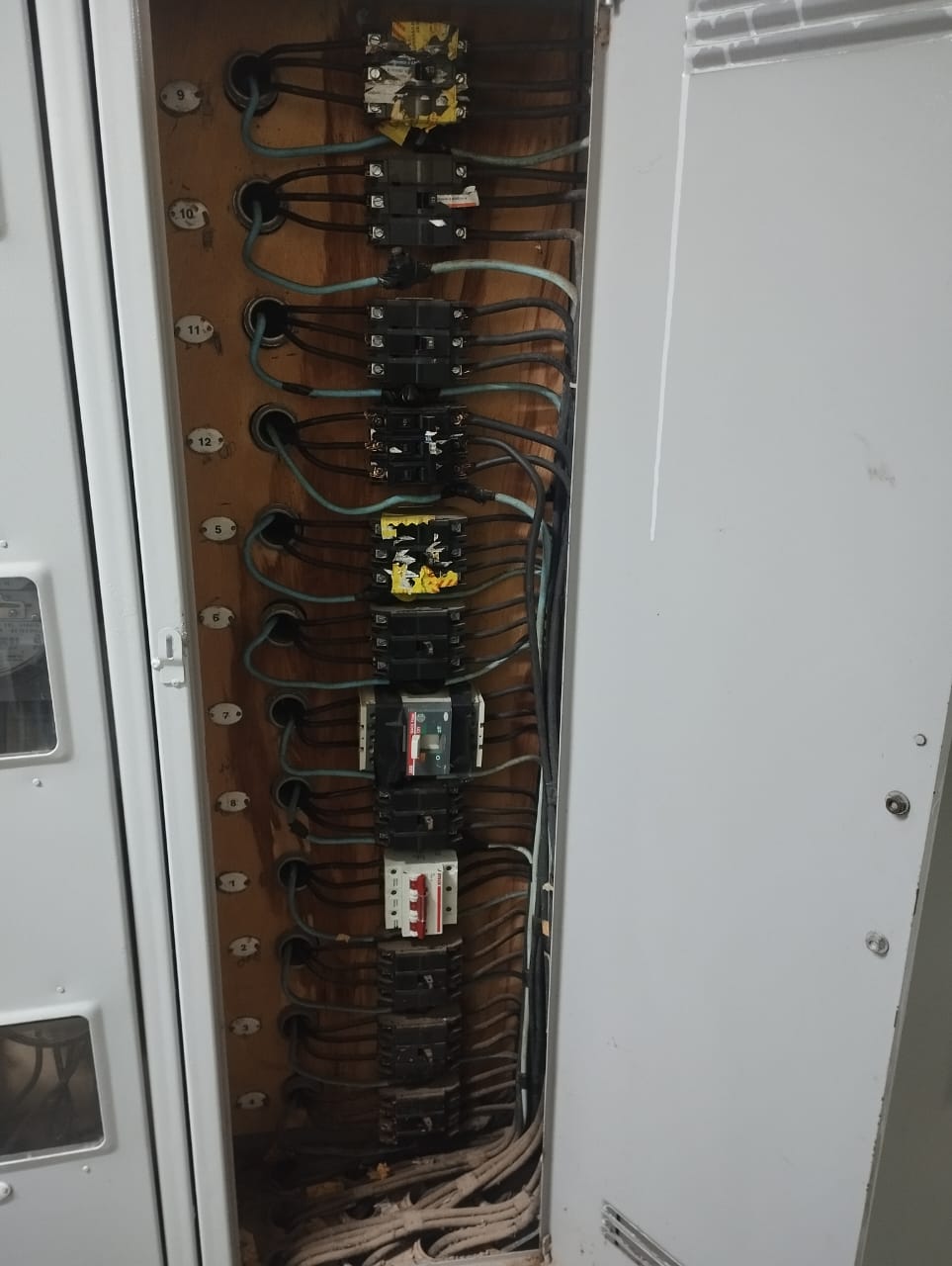 Painel elétrico industrial aberto, com disjuntores e contatores em coluna